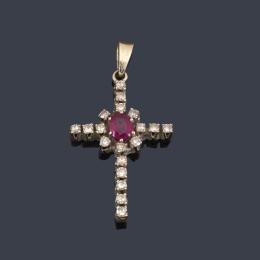 Lote 2494
Cruz con diamantes talla sencilla y centro de rubí talla oval en montura de oro blanco de 18K.