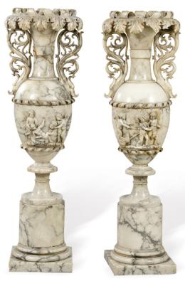 Lote 1083
Pareja de urnas de alabastro tallado, Italia primer tercio S. XX.
Con decoraicón de hojas de acanto en el borde y amorcillos y temática clasica en relieve