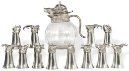 Lote 1431
Juego de jarra de cristal y metal plateado y doce vasos de metal plateado de Valenti h. 1960-70.