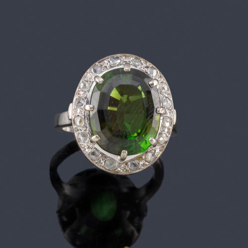  Anillo con turmalina verdelita talla oval de aprox. 6,90 ct con orla de diamantes talla rosa.