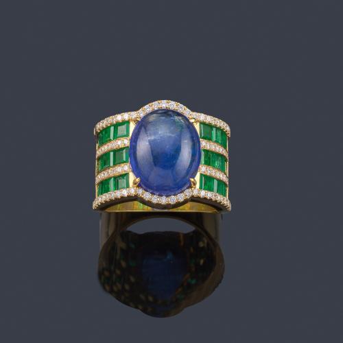  Anillo con zafiro en cabujón de aprox. 12,16 ct con tres bandas de esmeraldas calibradas en ambos lados y bandas de brillantes en montura de oro amarillo de 18K.