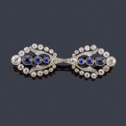  Broche-barrita con centro de zafiros talla oval dispuestos en disminución de tamaño, con orla de diamantes talla antigua de aprox. 4,50 ct en total.