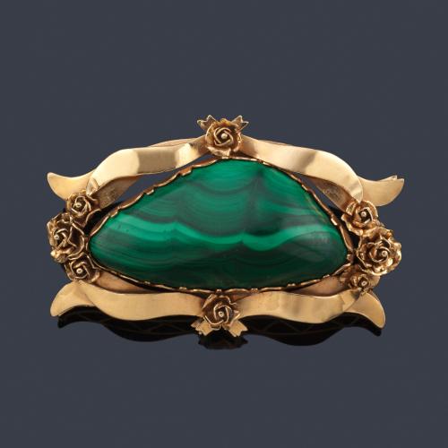  Broche con gran pieza de malaquita pulida enmarcada con diseño de bandas onduladas y motivos florales en montura de oro amarillo de 18K.