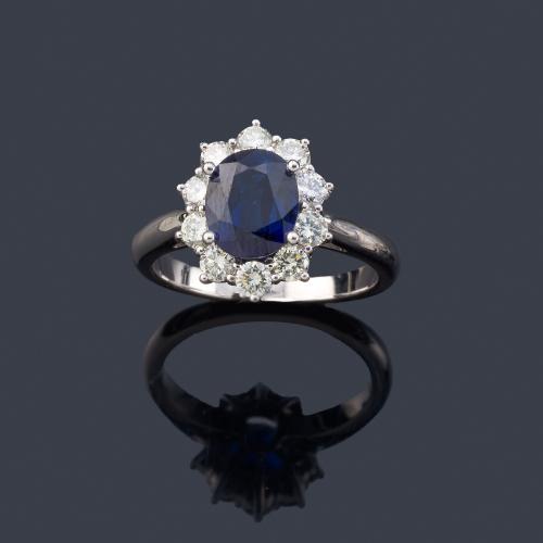  Anillo con zafiro talla oval de aprox. 2,00 ct con orla de brillantes en montura de oro blanco de 18K.