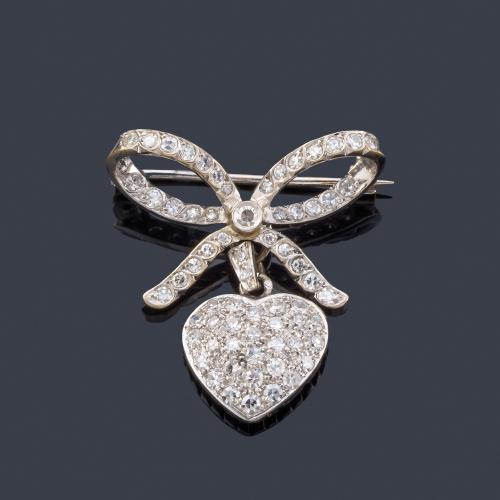 Lote 2527
Broche en forma de lazada con remate en forma de corazón con brillantes de aprox. 0,80 ct en total.
