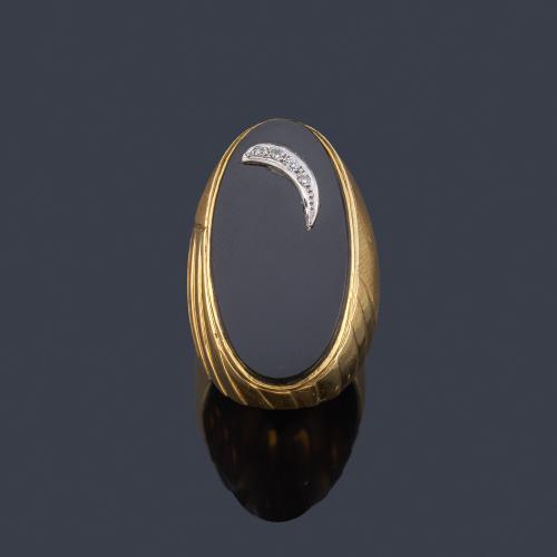  Anillo tipo lanzadera con pieza de ónix ovalada y detalle de diamantes, en montura de oro amarillo mate y brillo de 18K.