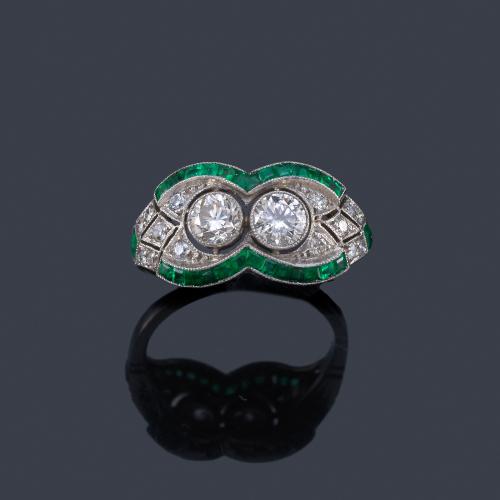 Lote 2040
Anillo con pareja de brillantes de aprox. 0,80 ct en total con orla de esmeraldas calibradas y diamantes.