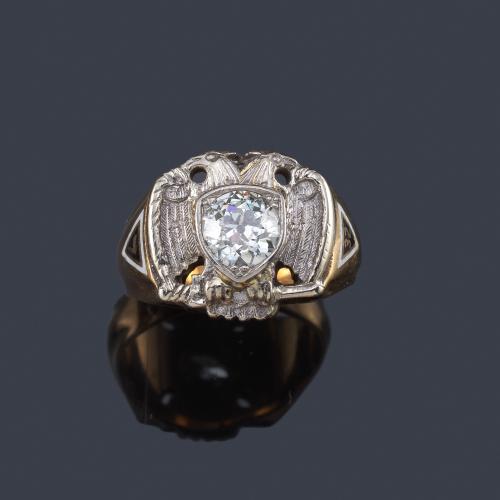 Lote 2093
Anillo con motivo central de escudo con 'águila bicéfala' y centro con un diamante talla antigua de aprox. 1,25 ct.