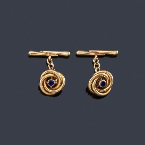  Gemelos con diseño de nudo con zafiro central en montura de oro amarillo de 18K.