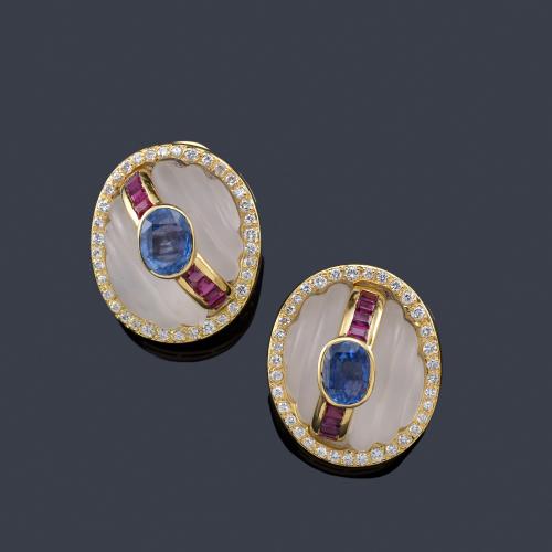 Lote 2269
Pendientes cortos con cristal de roca gallonado con centro de zafiro talla oval y banda de rubí calibrado.