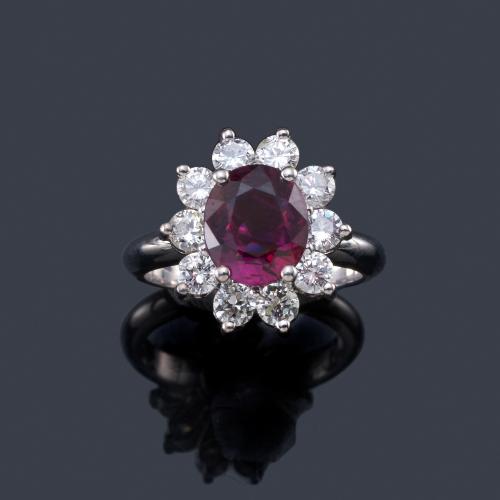 Lote 2318
Anillo con rubí talla oval de aprox. 3,10 ct con orla de brillantes de aprox. 1,36 ct en total.