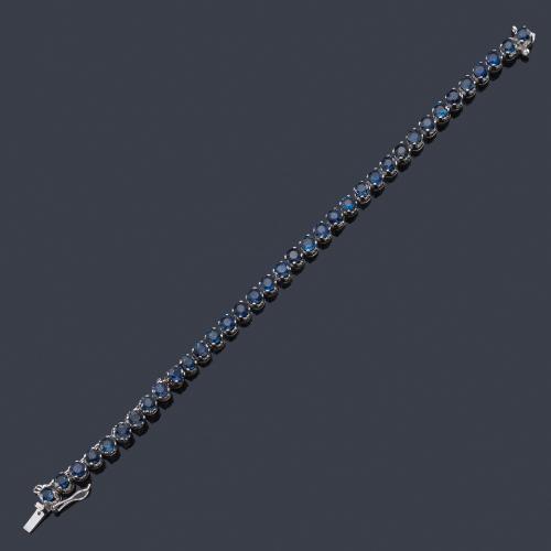  Pulsera rivière con zafiros talla redonda de aprox. 5,60 ct en total en montura de oro blanco de 18K.