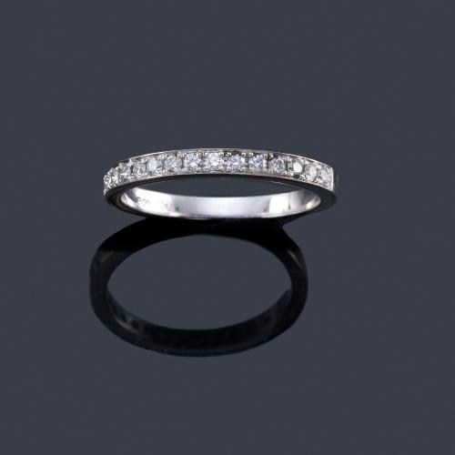  Media alianza con banda de brillantes en montura de oro blanco de 18K.