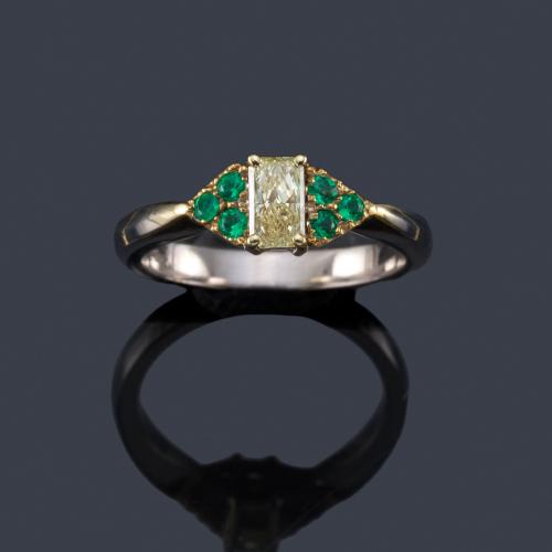  Anillo con diamante talla rectangular Fancy Yellow de aprox. 0,40 ct con esmeraldas en ambos lados. Certificado GIA.