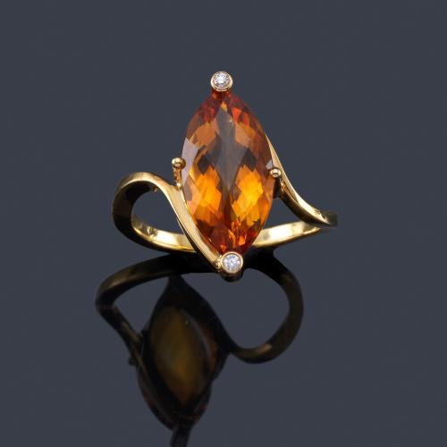 Lote 2408
Anillo con cuarzo citrino talla marquís de aprox. 5,50 ct con dos brillantitos, en montura de oro amarillo de 18K.