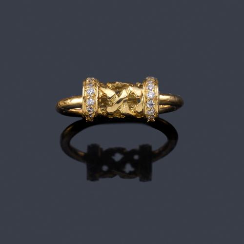  Anillo con motivo central cilíndrico con diseño calado y dos bandas caladas con brillantes.