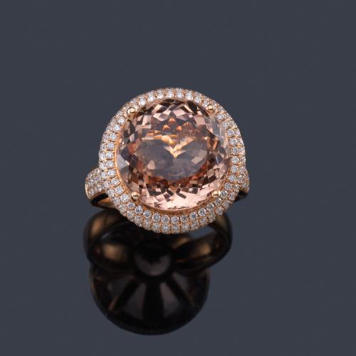  Anillo con morganita talla redonda de aprox. 9,55 ct con triple orla de brillantes de aprox. 1,05 ct en total.