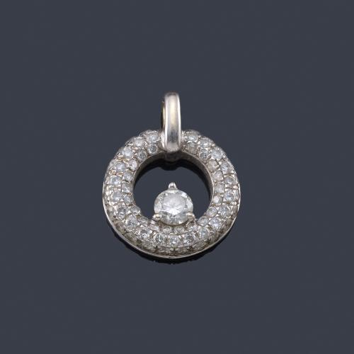 Lote 2478
Colgante circular cuajado de brillantes, con un brillante central de aprox. 0,25 ct, en montura de oro blanco de 18K.
