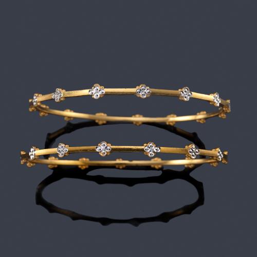  Pareja de brazaletes rígidos con decoración floral en oro amarillo de 22K.