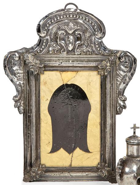 Lote 1255
"Santa Faz" en cristal eglomizado con marco de plata española repujada y cincelada S. XVIII.