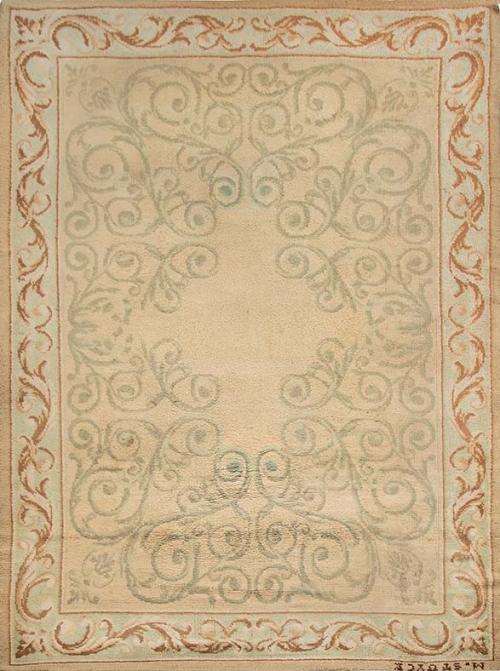  Alfombra española en lana de Miguel Stuyck, firmada.
Campo claro con roleos verdes y cenefa con hojas en oro.