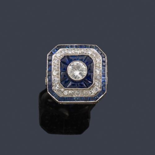 Lote 2100
Anillo estilo 'art decó' con diseño rectangular, con brillante central de aprox. 0,60 ct y doble orla de zafiros calibrados y brillantes de aprox. 0,77 ct en total.