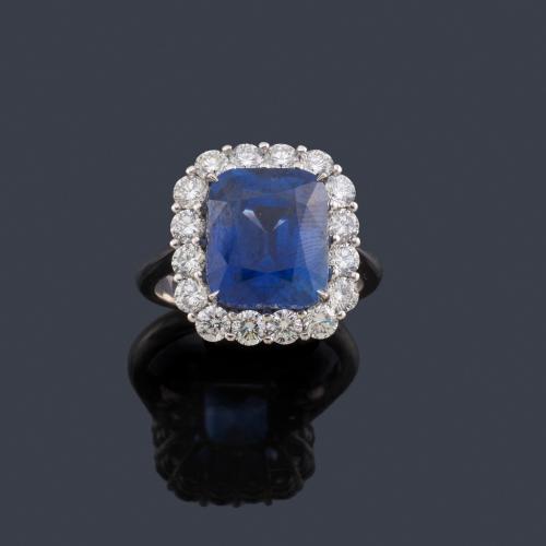 Lote 2103
Anillo con zafiro Ceylan (Sri Lanka) talla cushion de aprox. 7,003 ct con orla de brillantes de aprox. 1,36 ct en total. Certificado Bellerophon.