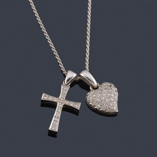  Cruz y colgante en forma de corazón cuajado de brillantes en montura y cadena de oro blanco de 18K.