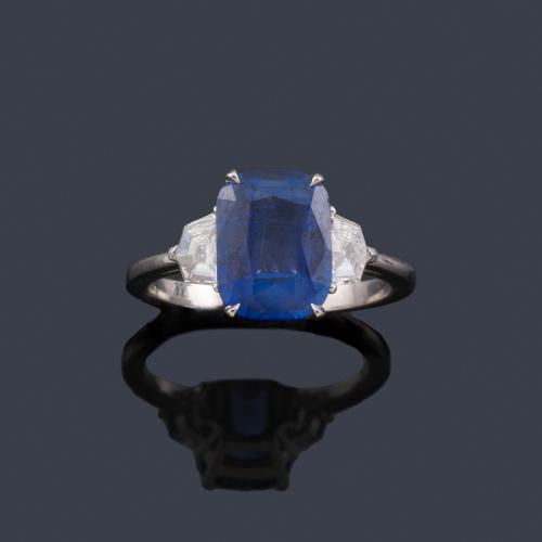 Lote 2237
Anillo con zafiro Ceylan (Sri Lanka) talla cushion de aprox. 4,00 ct con pareja de diamantes talla fantasía de aprox.0,46 ct en total. Con certificado Bellerophon.