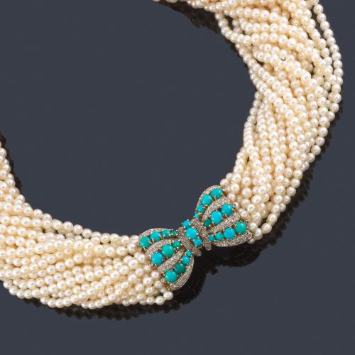 Lote 2292
Collar largo con veinte hilos de perlitas con un importante broche en forma de lazada con turquesas en cabujón intercalada con diamantes talla rosa.