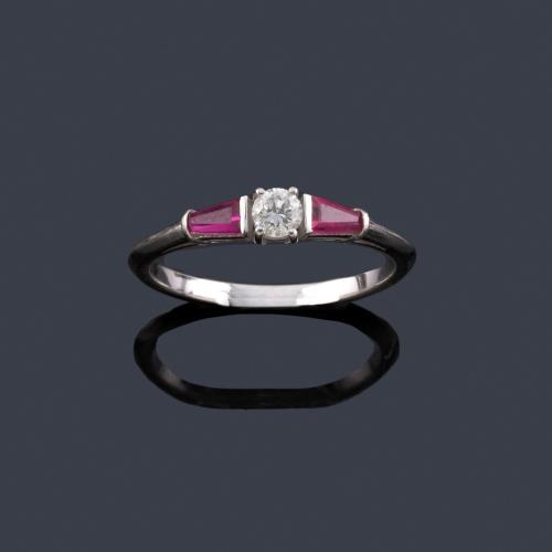 Lote 2367
Anillo con brillante central de aprox. 0,15 ct con dos rubíes talla trapecio.