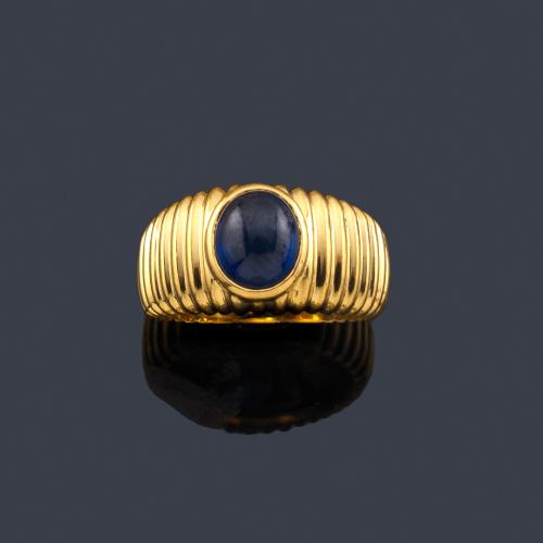  Anillo con zafiro central en cabujón en montura de oro amarillo gallonado de 18K.