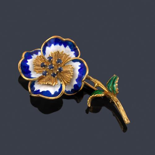  Broche en forma de flor con esmalte policromado con centro de zafiro, en montura de oro amarillo de 14K.