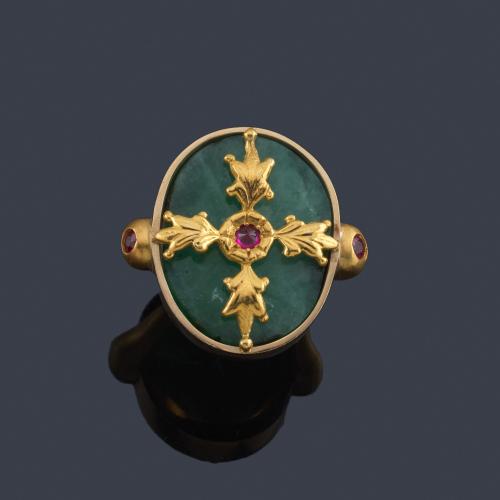  Anillo con piedra dura ovalada con decoración vegetal en oro amarillo y rubíes sintéticos.