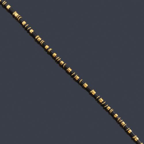 Lote 2385
Collar corto con motivos tubulares de ónix y oro amarillo de 18K.