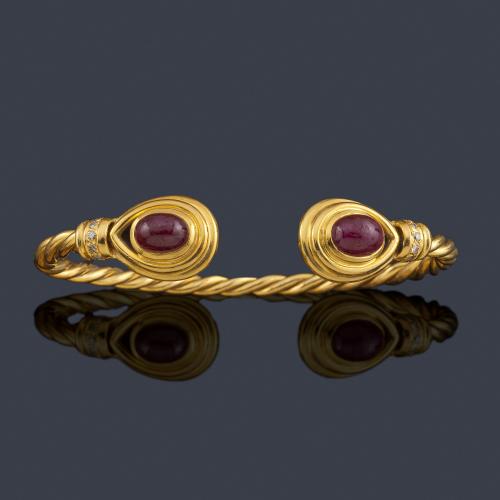  Pulsera rígida con diseño entorchado, rematado con dos rubíes en cabujón.