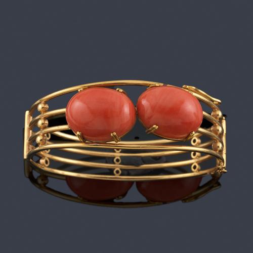  Pulsera rígida con pareja de cabujones de coral sobre montura de oro amarillo de 18K.