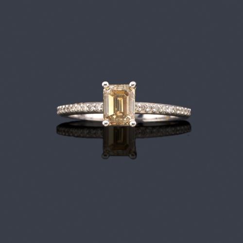 Lote 2500
Solitario con diamante Fancy Brownish Yellow talla esmeralda de aprox. 1,05 ct con brillantes de aprox. 0,11 ct en ambos brazos. Certificado AIG Worlwide.