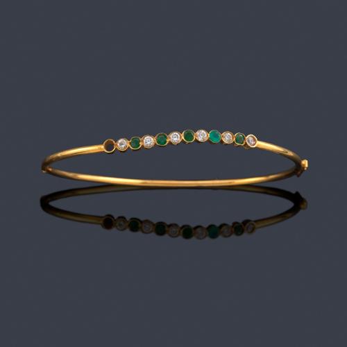  Pulsera rígida con brillantes intercalado con esmeraldas en montura de oro amarillo de 18K.