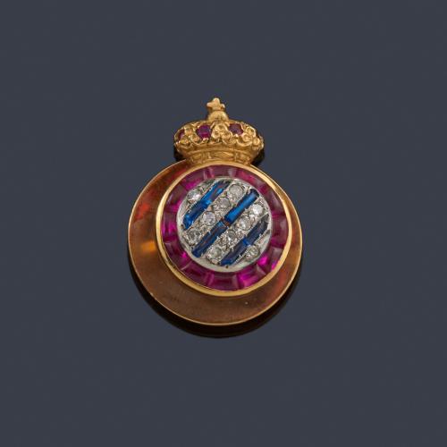 Lote 2536
Insignia del club Español en oro amarillo de 18K con rubíes, zafiros sintéticos y diamantes.