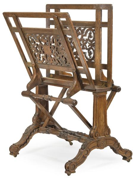  Atril de biblioteca en madera de caoba, con patas unidas con chambrana torneada y panel en madera recortada.