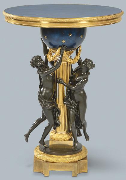  Henry Dasson (1825-1896)
Mesa velador redonda, con tapa de lapislázuli, sobre pedestal en forma de columna clásica acanalada rodeada de figuras femeninas representando a las tres gracias en bronce pavonado sujetando una guirnalda.