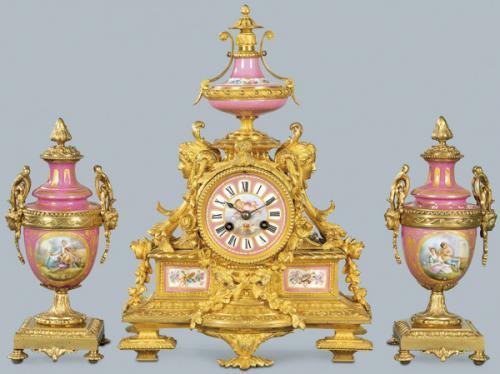  Guarnición formada por reloj de sobremesa y dos copas Napoleón III, estilo Luis XVI en bronce y porcelana