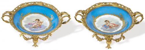  Pareja de centros de mesa en porcelana tipo Sèvres con figuras de angeles dentro de una orla enmarcada por ramas y hojas doradas sobre fondo azul turquesa, con montura de bronce estilo Luis XV.
Francia, finales S. XIX