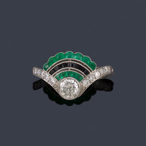 Lote 2064
Anillo con diseño en forma de abanico con brillante central de aprox. 0,60 ct y bandas curvadas de zafiros y esmeraldas calibradas.
