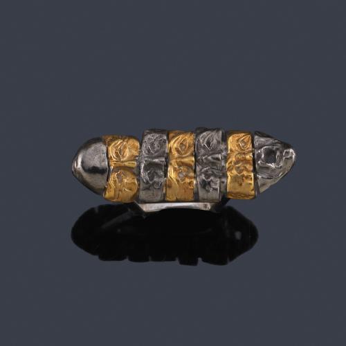 Lote 2232
BENJAMIN KAVAZOVIC
Anillo con múltiples máscaras de carnaval unidas entre sí realizadas en oro amarillo de 18K y plata pavonada.