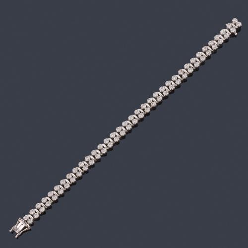 Lote 2383
Pulsera rivière tipo doble rosetón de brillantes en montura de oro blanco de 18K.