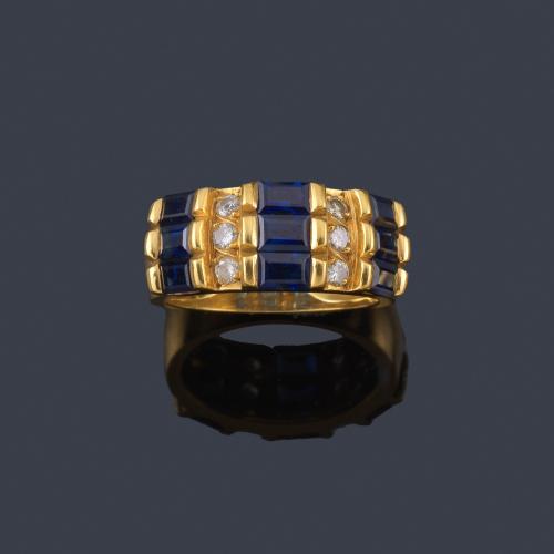  Anillo con frente de zafiros intercalado con brillantes en montura de oro amarillo de 18K.