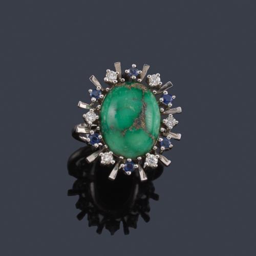 Lote 2409
Anillo con turquesa central en cabujón con orla de brillantes y zafiros intercalados.