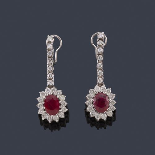  Pendientes largos con pareja de rubíes talla oval de aprox. 1,00 ct cada uno, con orla de brillantes en montura de oro blanco de 18K.